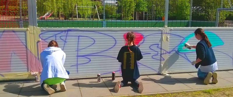 Schulsozialarbeit an der Biesalski-Schule, Förderzentrum, Förderschwerpunkt „Körperliche und motorische Entwicklung“, Grundschule und integrierte Sekundarschule, Gruppe spielender Schülerinnen gestalten ein Graffiti