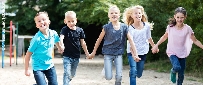 Schulbezogene Sozialarbeit an der Grundschule an der Marie, Berlin Prenzlauer Berg, Hand in Hand laufende fröhliche Kindergruppe