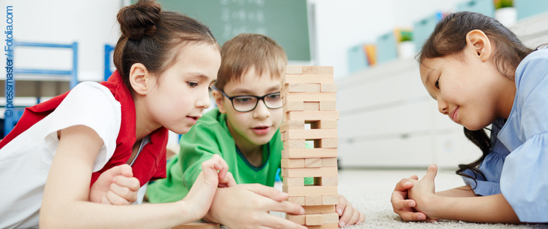 Schulbezogene Sozialarbeit an der Reinhardswald-Grundschule, Berlin Kreuzberg, drei Kinder beim Wackelturm-Spiel